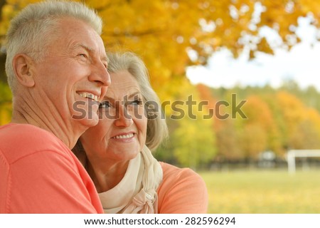 Beautiful happy old people in the autumn park