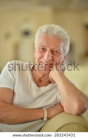 Portrait of elderly man sitting in armchair, warm tone