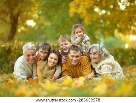 Happy smiling family relaxing in autumn park