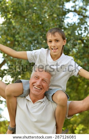 happy grandfather with his grandson for a walk in a summer park