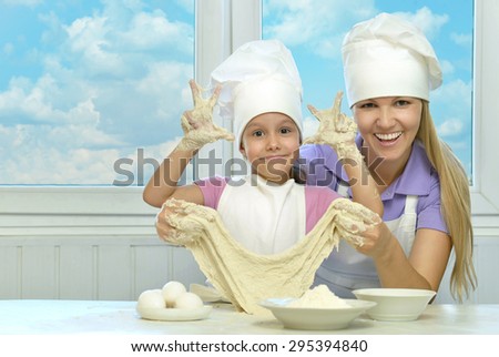 Adorable mother and daughter cooking together in the kitchen