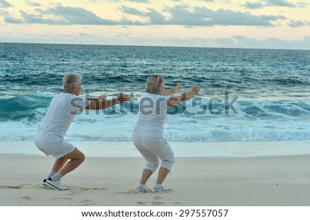 Happy Senior couple exercising in summer on  seashore