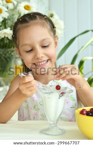 Portrait of little girl eating sweet  dessert with berries