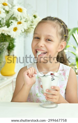 Portrait of little girl eating sweet  dessert with berries