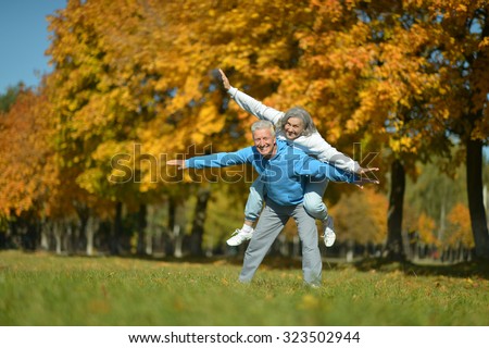 Portrait of a happy senior couple resting at autumn park