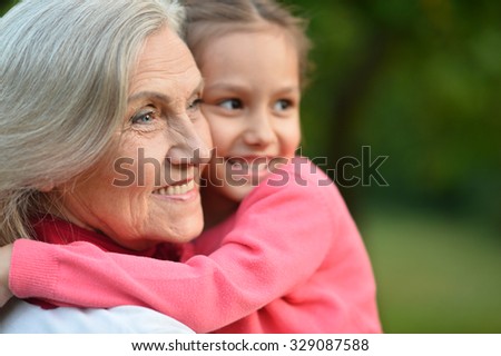 Little cute girl with her grandmother in summer park