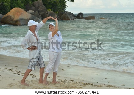 Beautiful happy elderly couple dancing at tropical resort