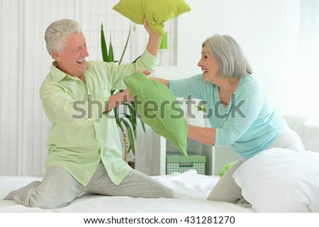senior couple playing with pillows