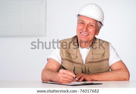 senior builder writing a list on white