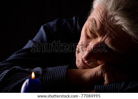 old man looking at the burning candle