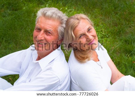 happy elderly couple in white clothes at nature
