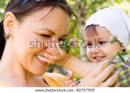 happy mom and daughter smiling at nature