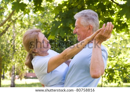 portrait of an old couple dancing at nature