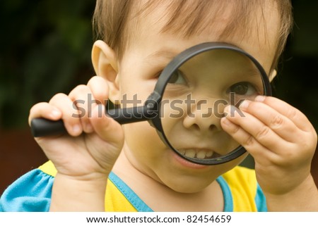 funny portrait of a girl with loupe