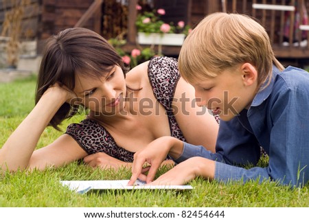 portrait of a mom and son reading at nature