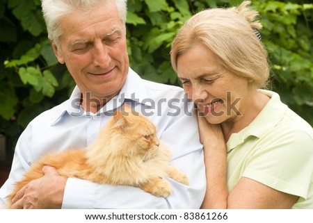 cute elderly couple with a cat at nature