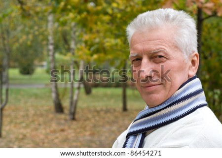 portrait of a nice old man posing at nature