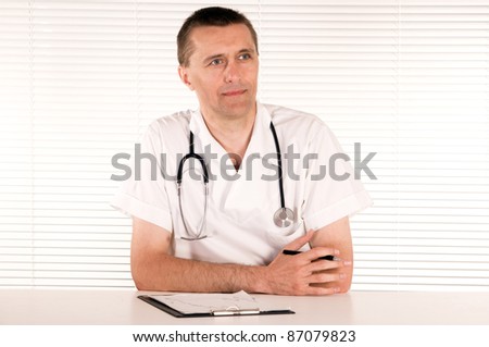 portrait of a cute doctor at table on white