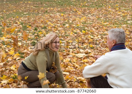 happy old couple posing at autumn park
