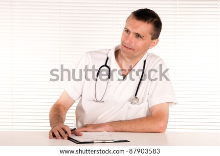 portrait of a cute doctor at table on white