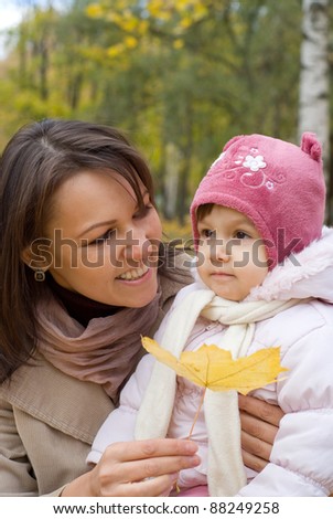 portrait of a cute mom with daughter in forest