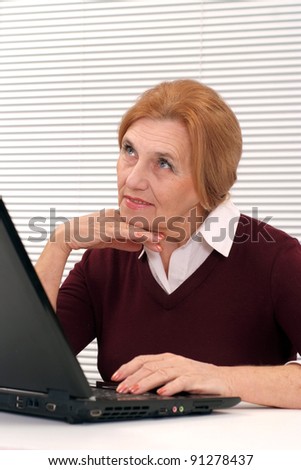 portrait of a cute old woman with computer