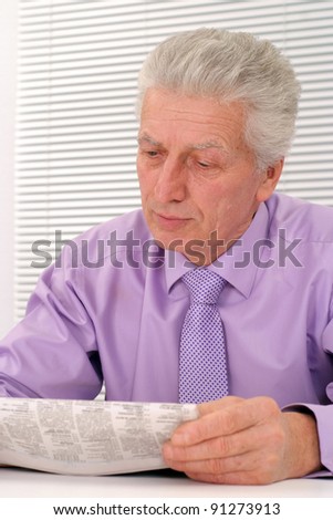 portrait of a cute old man reading newspaper