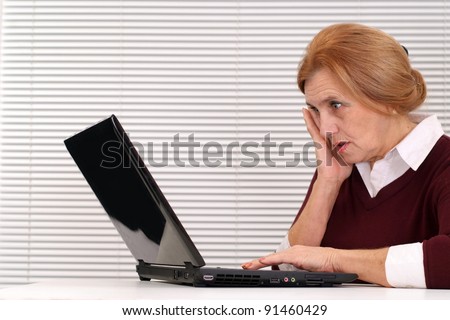 portrait of a cute old woman with computer