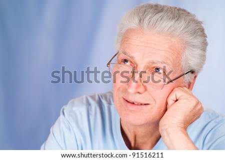 old man posing on a blue background