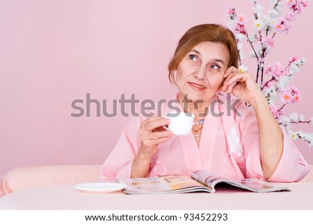 portrait of an old woman reading magazine