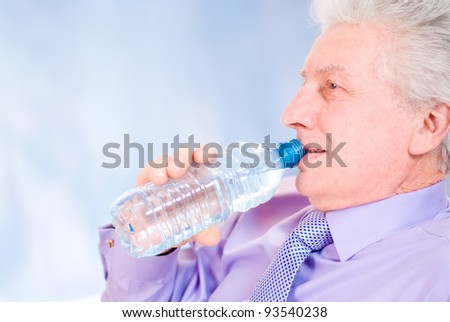 old businessman drinking water from the bottle