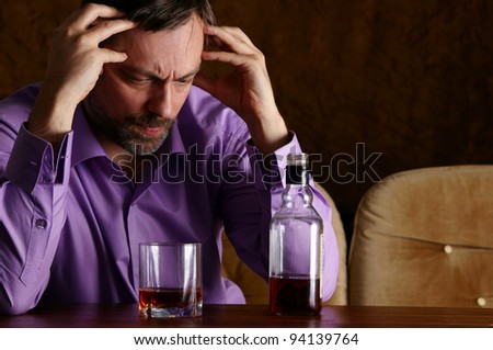 cute young man drinks whiskey at table