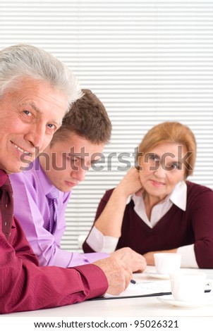nice three business people sitting at table
