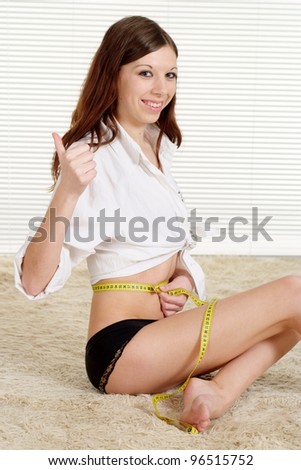 The ideal waist of the girl sitting on a light background