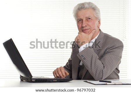 mature man sitting at the computer on a white background