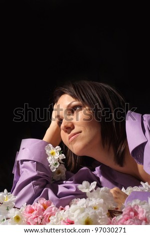 Portrait of a beautiful nice woman in a shirt in the flower is on a black background