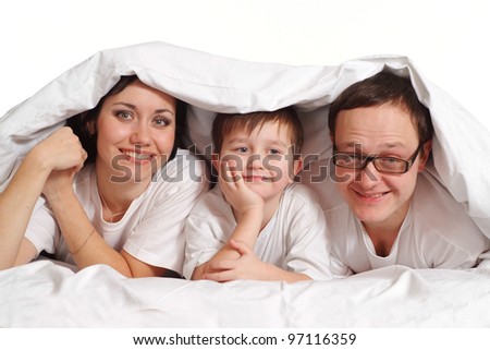 Family of three under a blanket on the bed on a white background