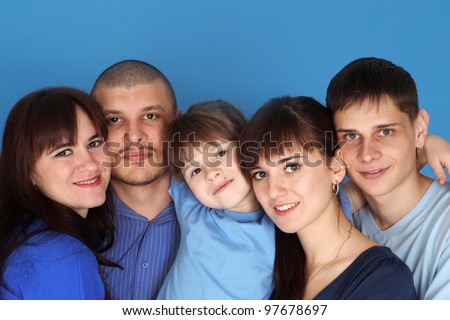 Caucasian beautiful nice family consisting of five people together on a blue background