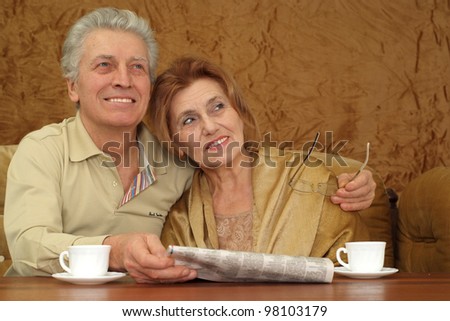 a woman with good man sitting on a sofa on a brown background