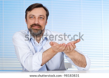Bliss business man sitting at a table and working on a light background