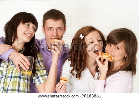Happy luck Caucasian campaign of four people eating pizza on a light background
