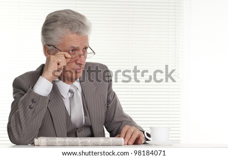 An business man in glasses sitting on a light background