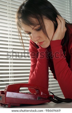 Beautiful Caucasian depression woman with a phone on a light background