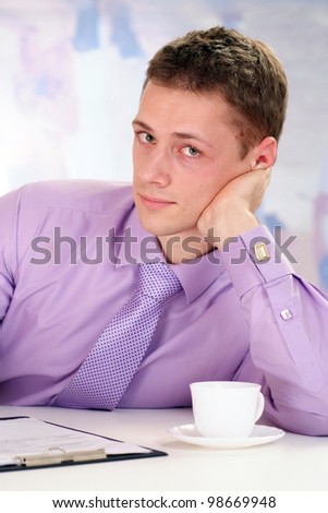 young business man sitting on a light background