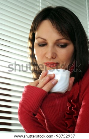 Beautiful caucasian luck woman with a cup on a light background