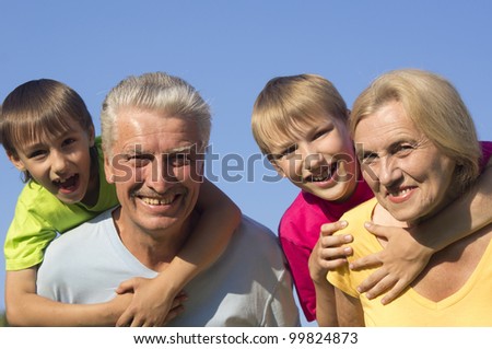 Happy Caucasian gladness grandparents with grandchildren with fool on the street