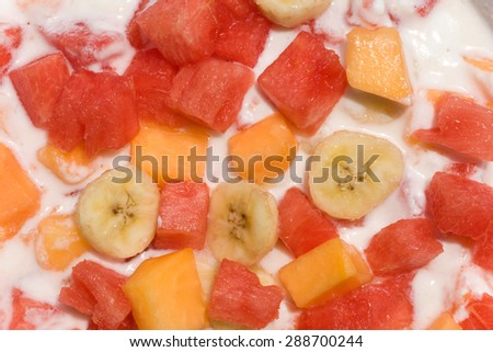 Fresh mixed fruit salad with banana, papaya,watermelon in milk