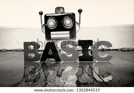 robot head and the word BASIC on a old wooden floor  solarized  monochrome