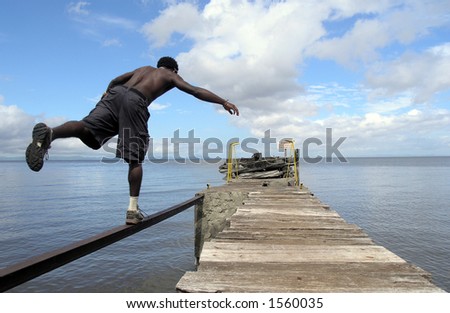 man balancing on a rail over a lake
