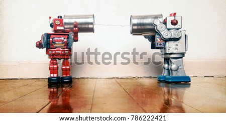 tow retro robots talk on tin can phones on an old wooden floor with reflection